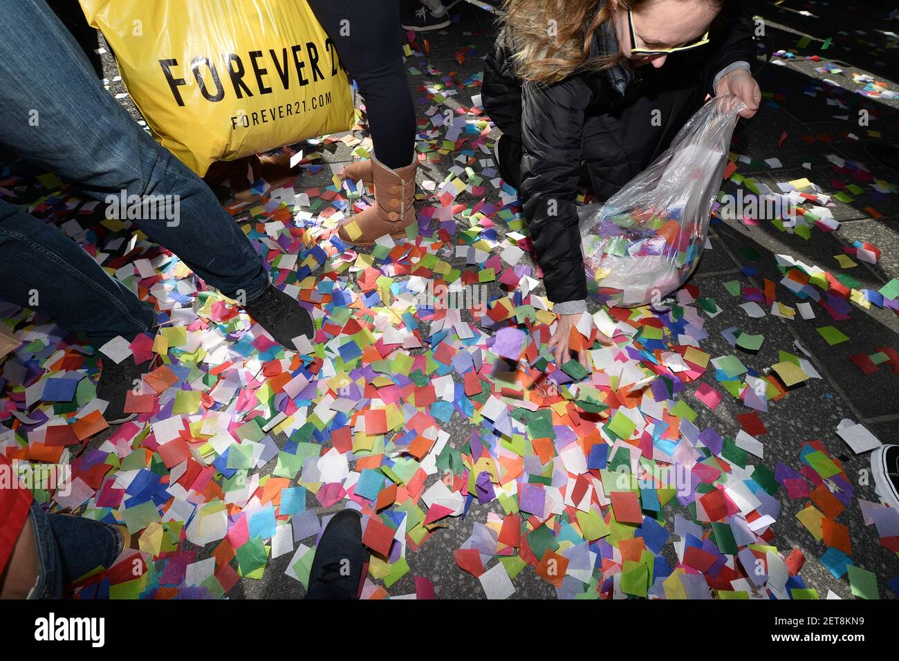 A woman gathers strewn confetti after the 