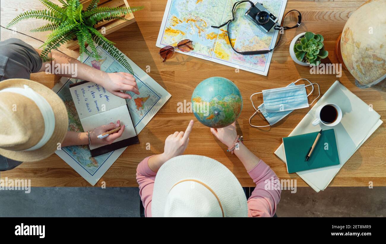 Top view of young couple with maps planning vacation trip holiday, desktop travel concept. Stock Photo
