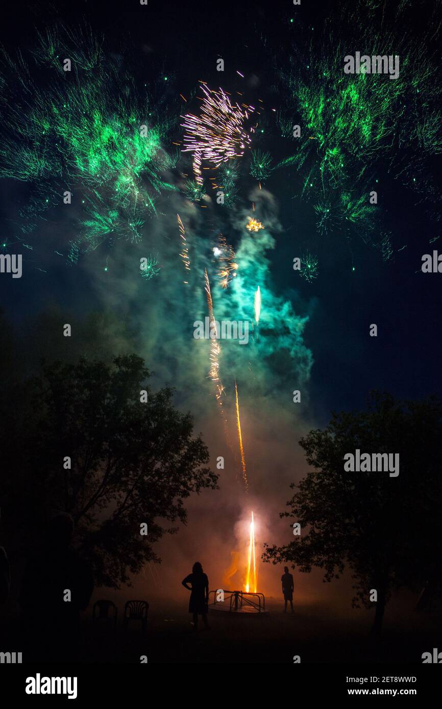 the silhouette of two men and some fireworks Stock Photo