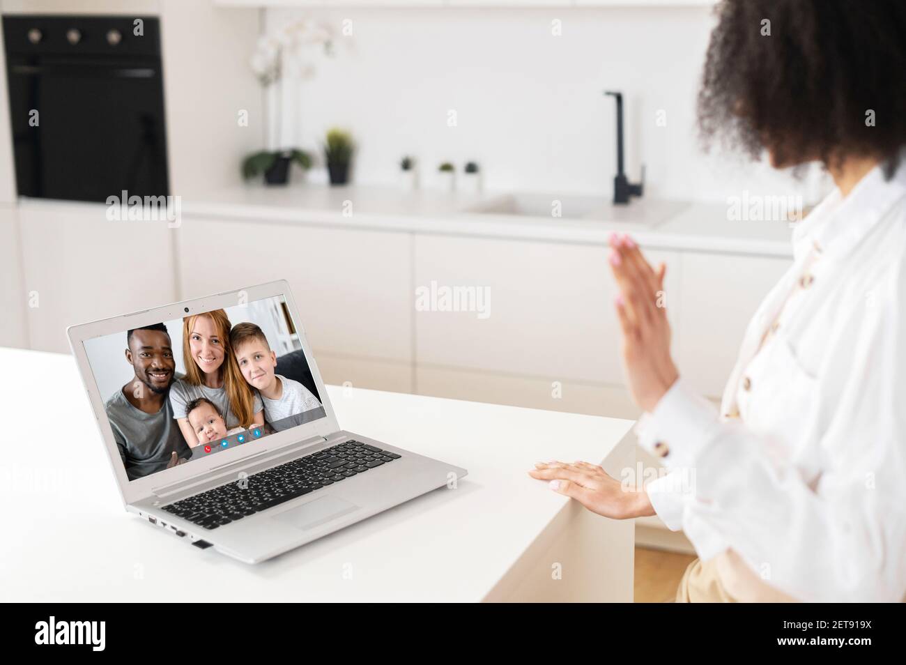Focus on screen with happy multiracial family, making video call with grown up young daughter woman or sister, chatting communicating online using computer application, staying at home on isolation Stock Photo