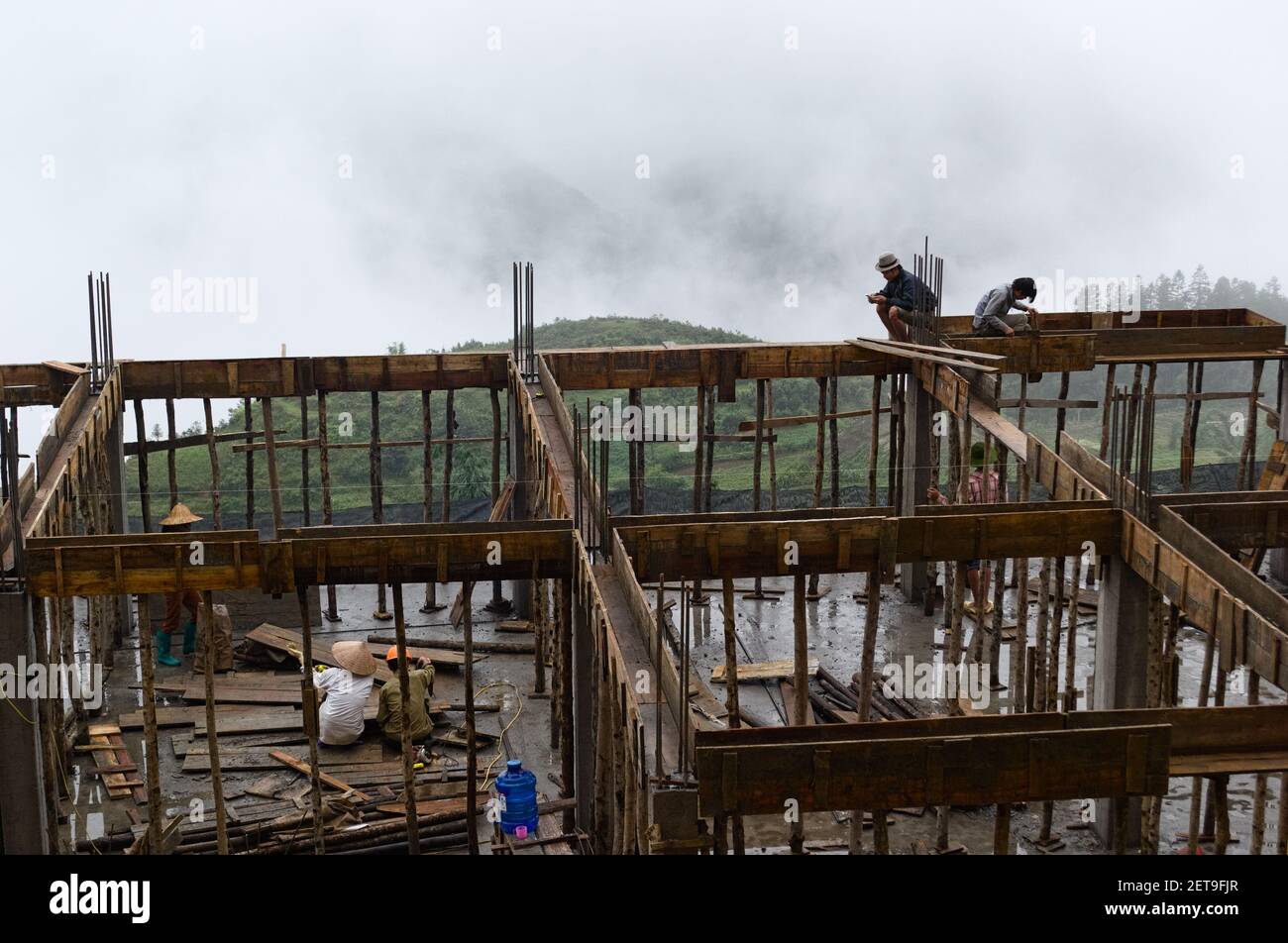 October, 2015 - Sa Pa, Vietnam: Asian people working on construction site on bamboo scaffolding. Stock Photo