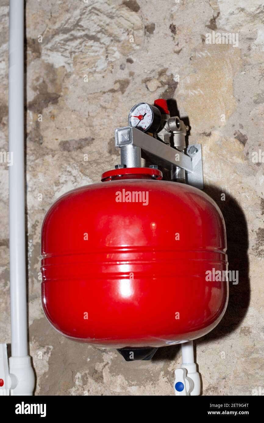 an expansion tank for the water heating system to regulate the volume of the coolant. Heating of a private residential building. Stock Photo