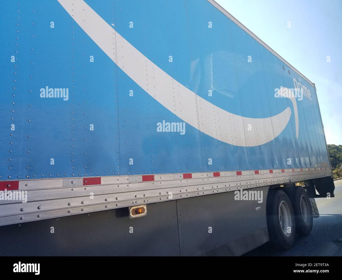 Side view of tractor trailer semi truck with logo for Amazon Prime