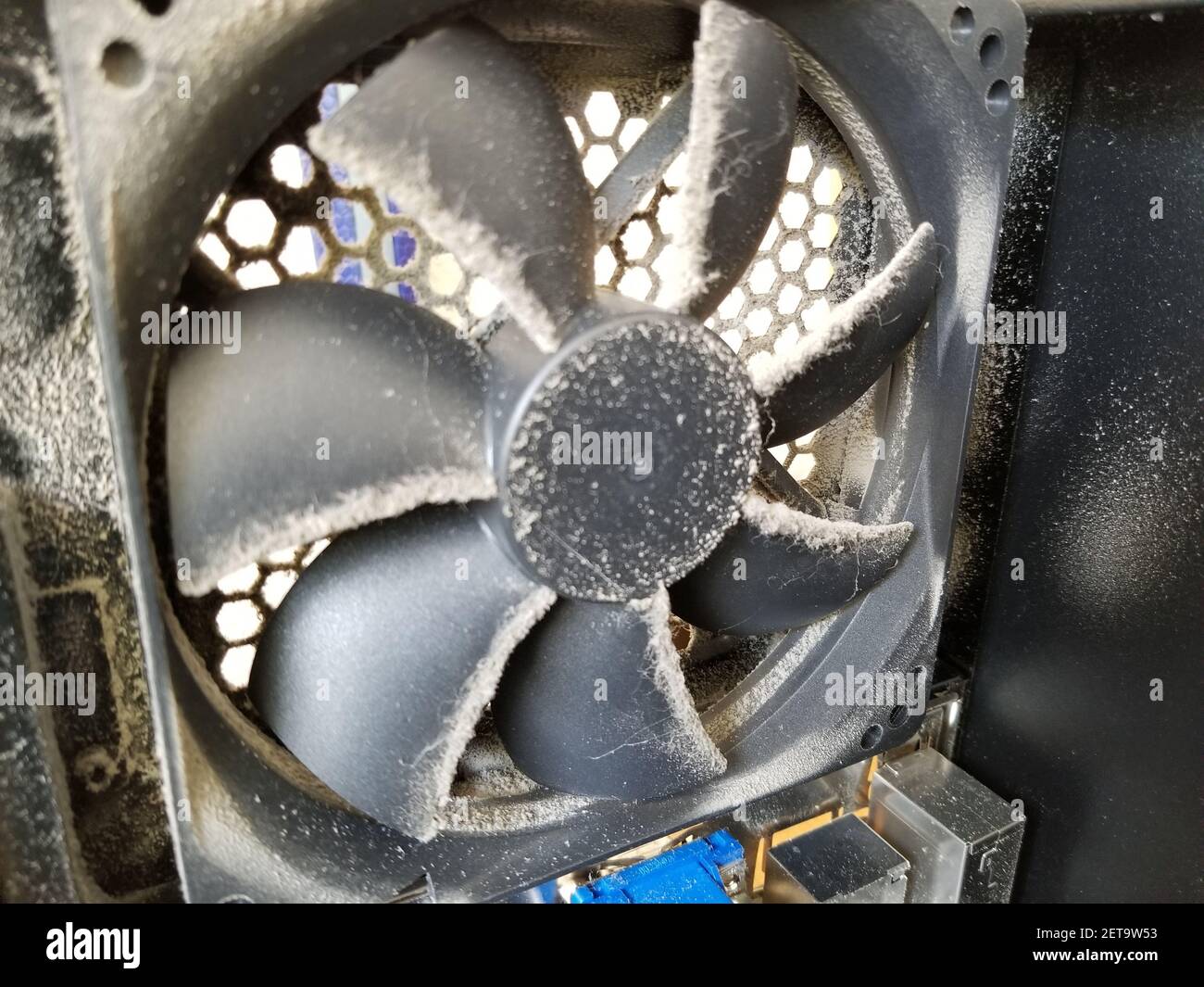 Dusty cooling fan in the interior of a computer used for cryptocurrency  mining of Bitcoin alternatives; as cryptocurrency mining computers often  run throughout the day and night, they require constant cooling and