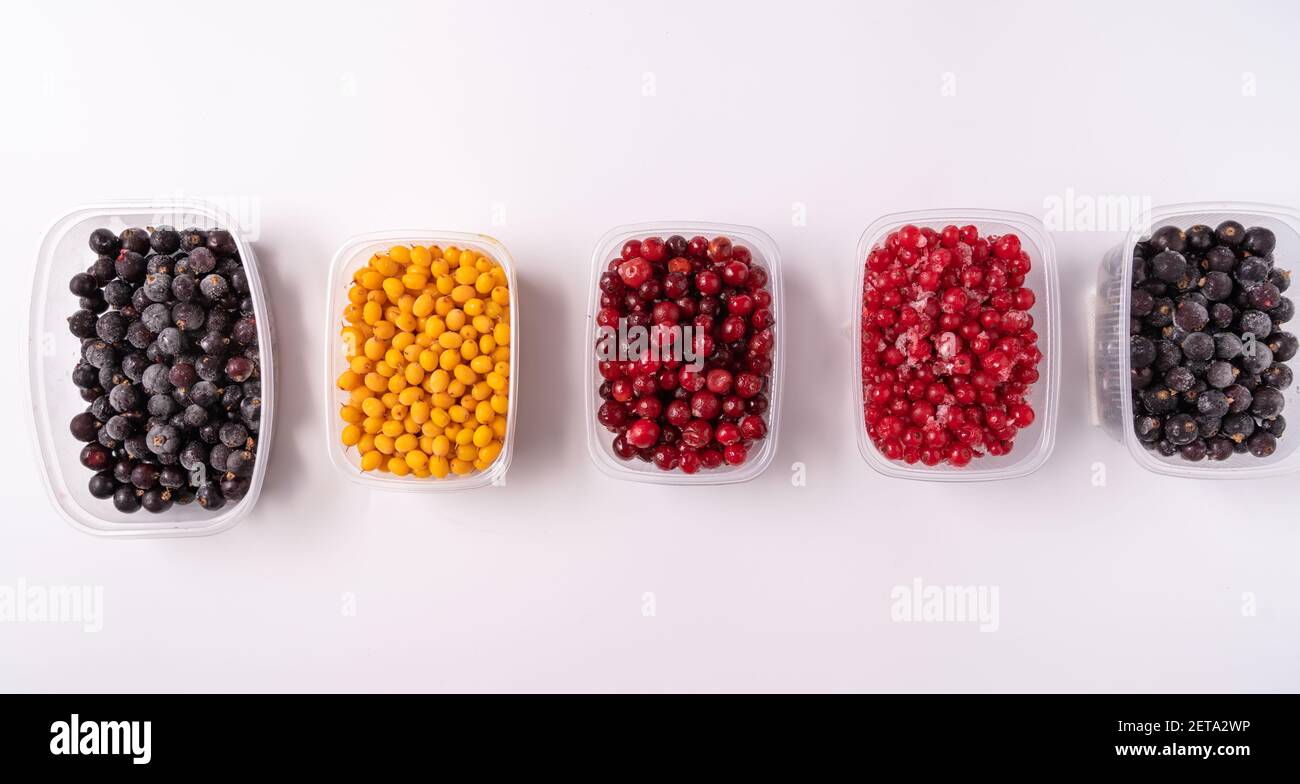 Frozen berries in plastic boxes isolated on white background Stock Photo