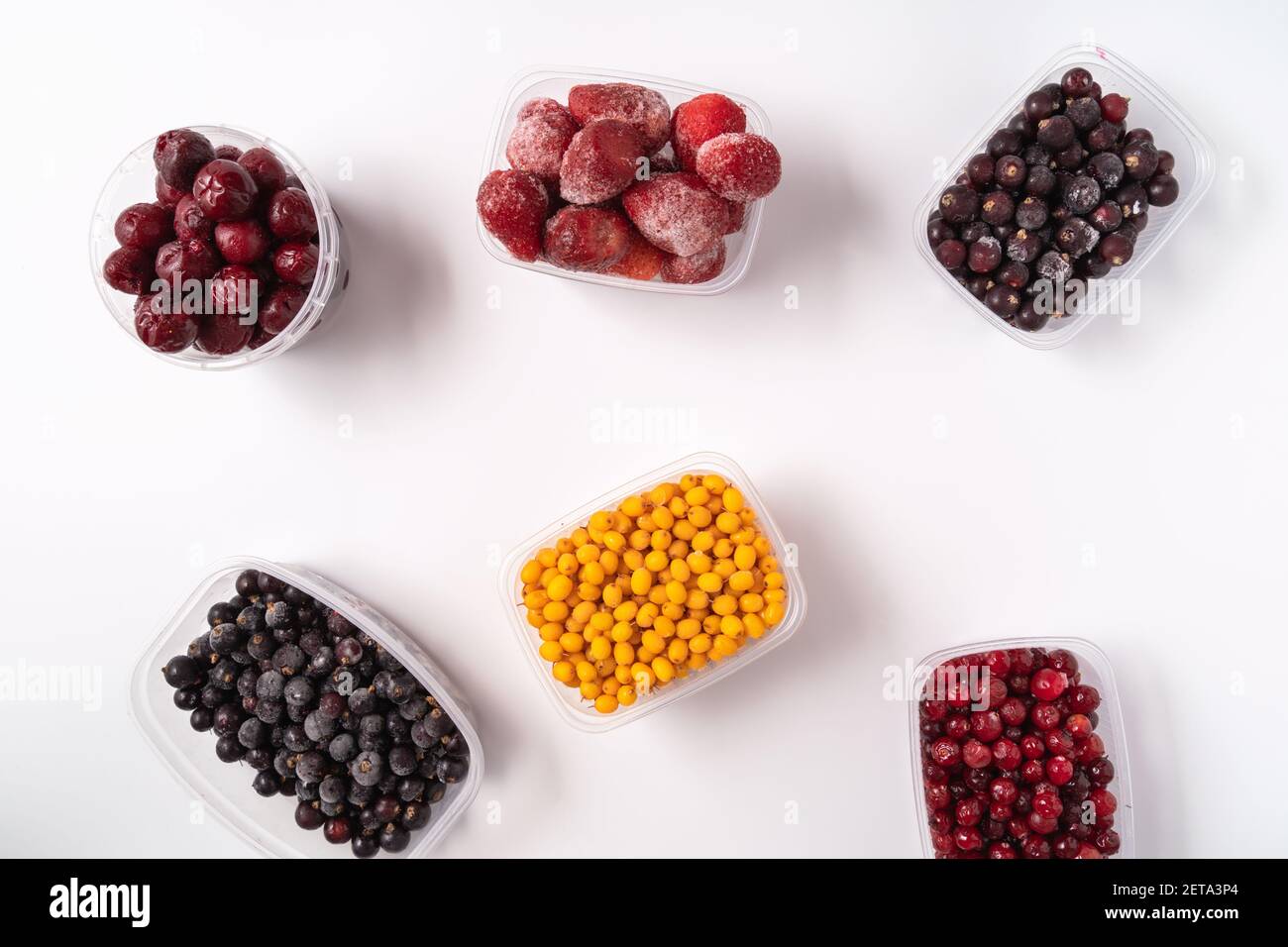 Frozen berries in plastic boxes isolated on white background Stock Photo