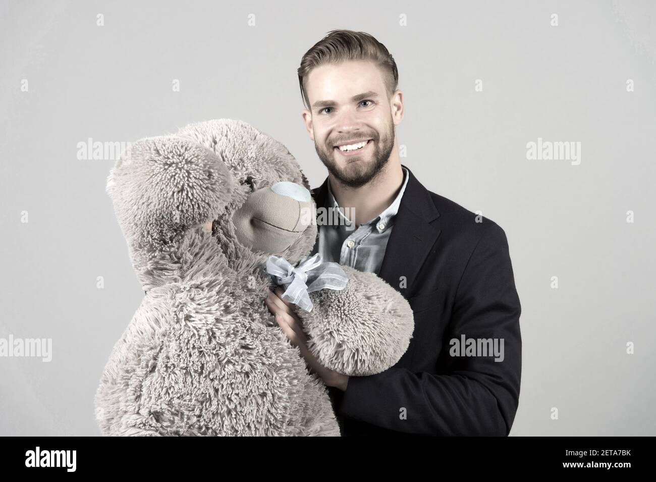 It is never too late to have happy adulthood. Man hols big teddy bear grey background. Birthday gift concept. Teddy bear pleasant surprise. Guy happy hold bear. Man cute gift surprise. Grown