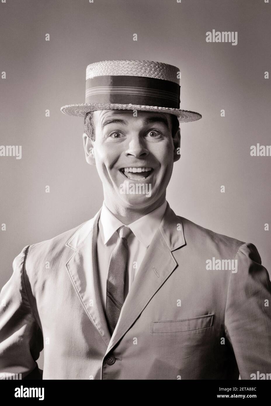 1960s LAUGHING MAN IN STRAW BOATER HAT AND SUMMER SUIT AND TIE WITH ENTHUSIASTIC SILLY FACIAL EXPRESSION LOOKING AT CAMERA - bs00433 CAM001 HARS PERSONS CHARACTER MALES B&W EYE CONTACT BUG-EYED SUIT AND TIE HUMOROUS HAPPINESS EXCITEMENT CAM001 ZANY COMICAL PRIDE ENTHUSIASTIC COMEDIAN OPEN MOUTH NECKTIE COMEDY JOYFUL STYLISH WACKY WIDE EYED STORY MAN EXAGGERATED MID-ADULT MID-ADULT MAN BLACK AND WHITE CAUCASIAN ETHNICITY OLD FASHIONED OLD-FASHIONED Stock Photo