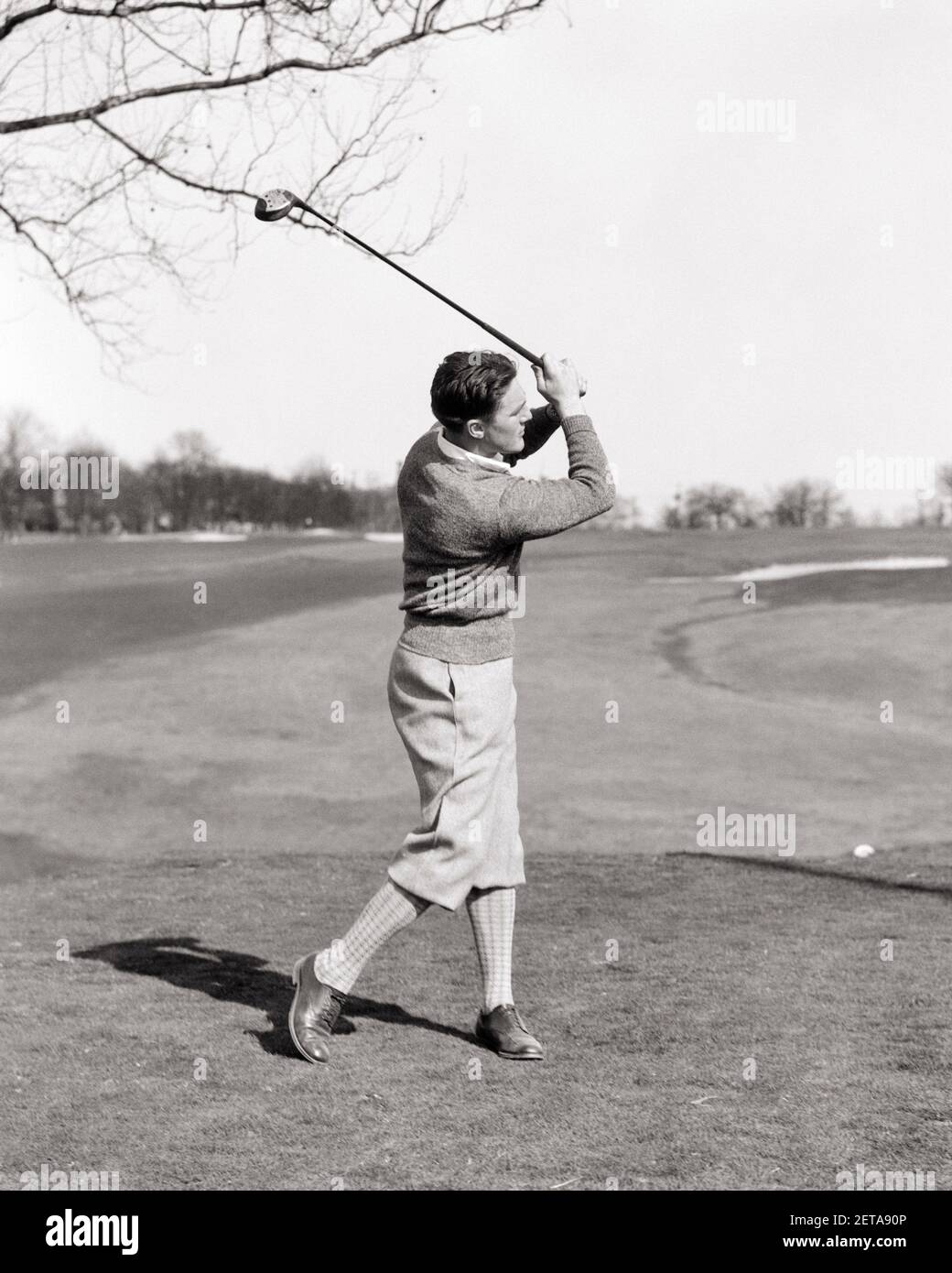 1920s 1930s MAN GOLFER FULL SWING TEEING OFF WEARING SWEATER PLUS FOURS - g1656 HAR001 HARS COPY SPACE FULL-LENGTH PHYSICAL FITNESS PERSONS MALES GOLFING ATHLETIC B&W ACTIVITY PHYSICAL GOLFERS LEISURE STRENGTH RECREATION ATHLETES FLEXIBILITY LINKS MUSCLES STYLISH FOURS PLUS TEEING YOUNG ADULT MAN BLACK AND WHITE CAUCASIAN ETHNICITY HAR001 OLD FASHIONED Stock Photo