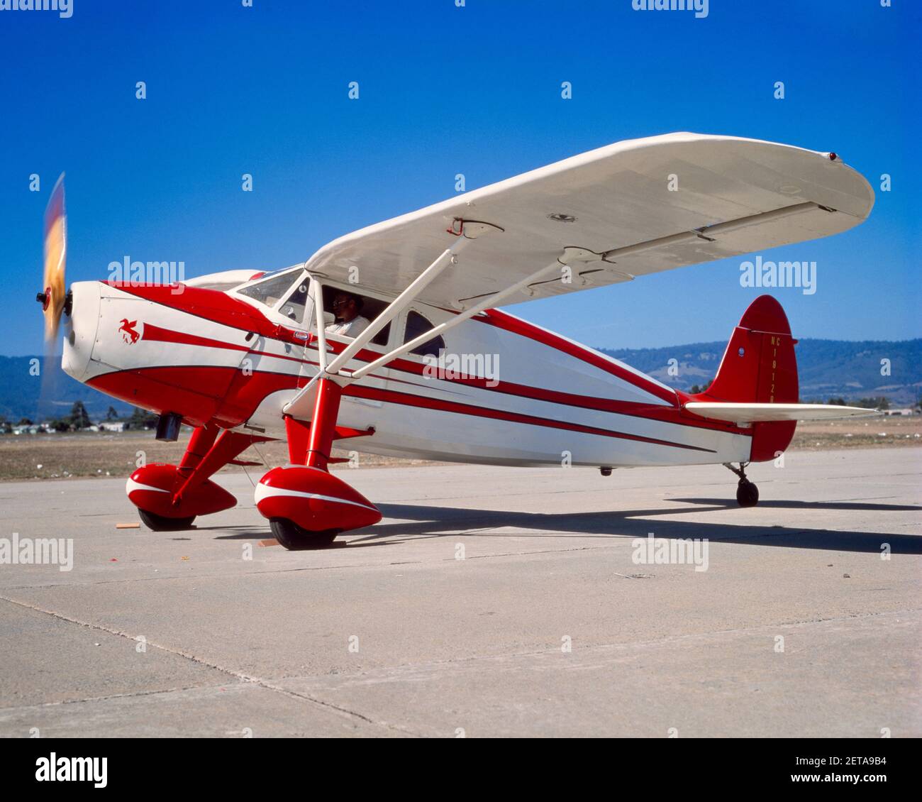 1930s CESSNA AIRMASTER ON TARMAC WITH ENGINE RUNNING PROPELLER BLADES TURNING BLURRED MOTION - ka5525 PHT001 HARS RED AND WHITE Stock Photo