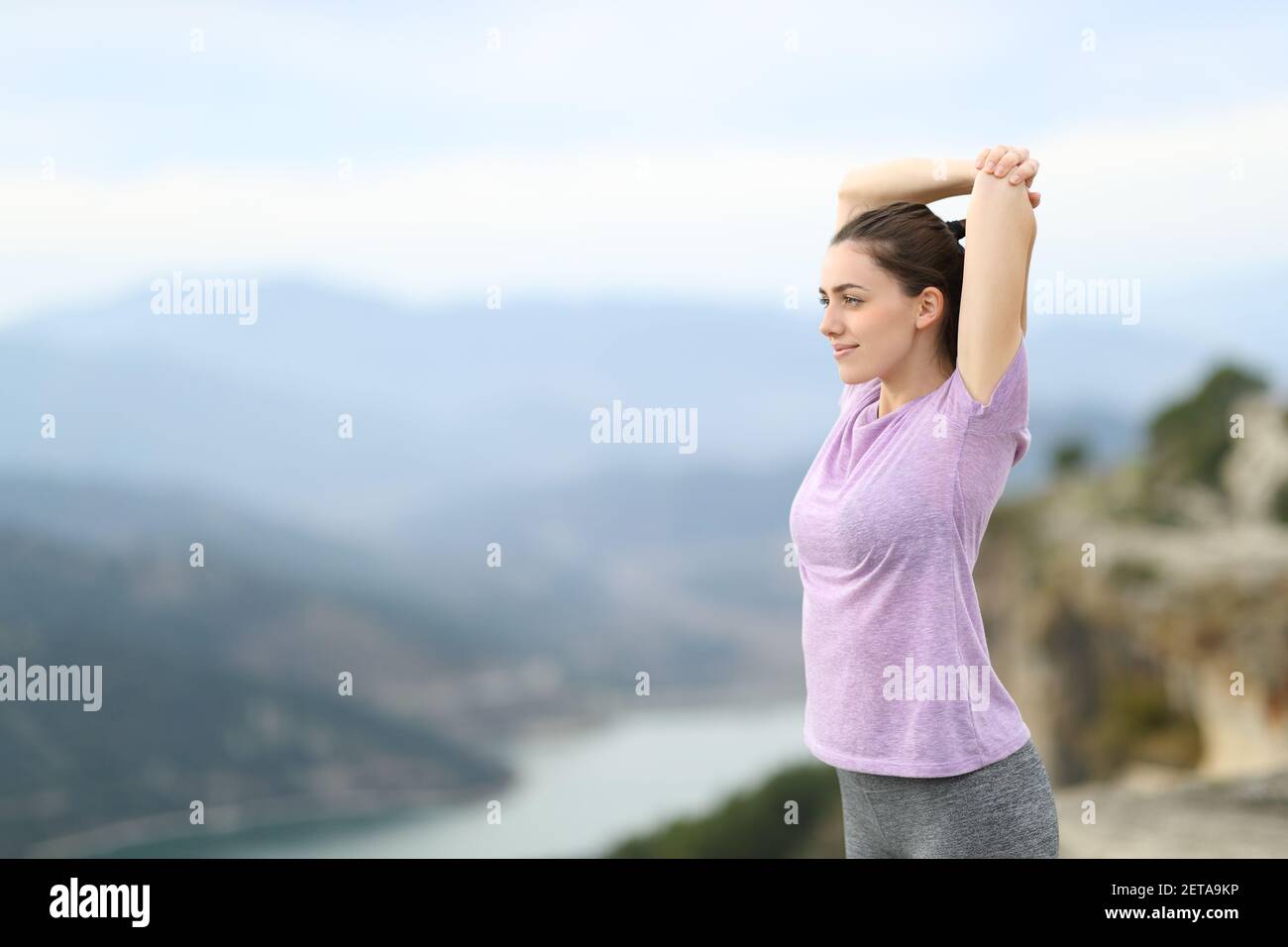 Satisfied jogger stretching arms after exercise in the mountain Stock Photo