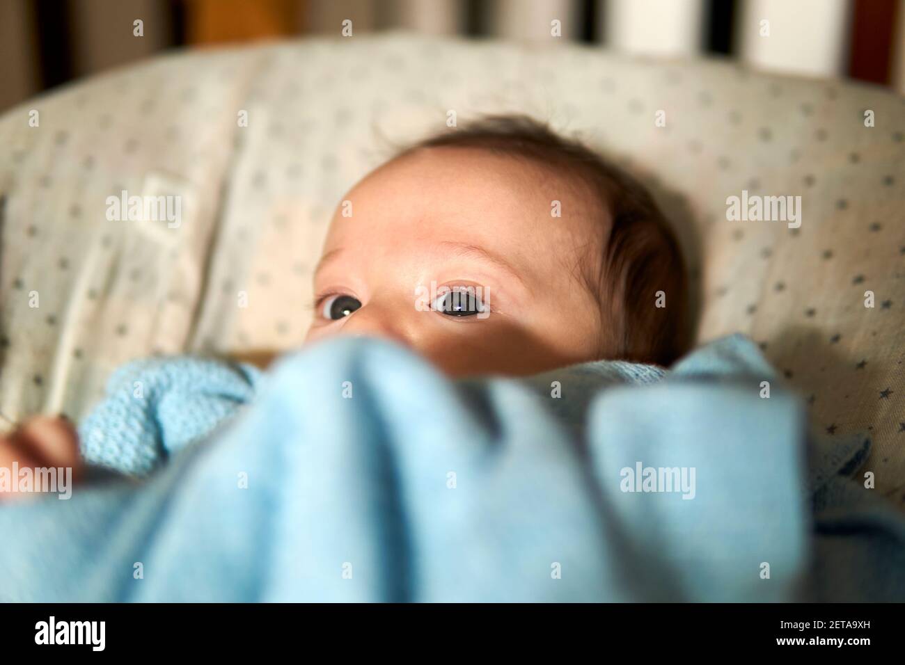two-month-old baby lying in a hammock looking askance. pretty eyes Stock Photo