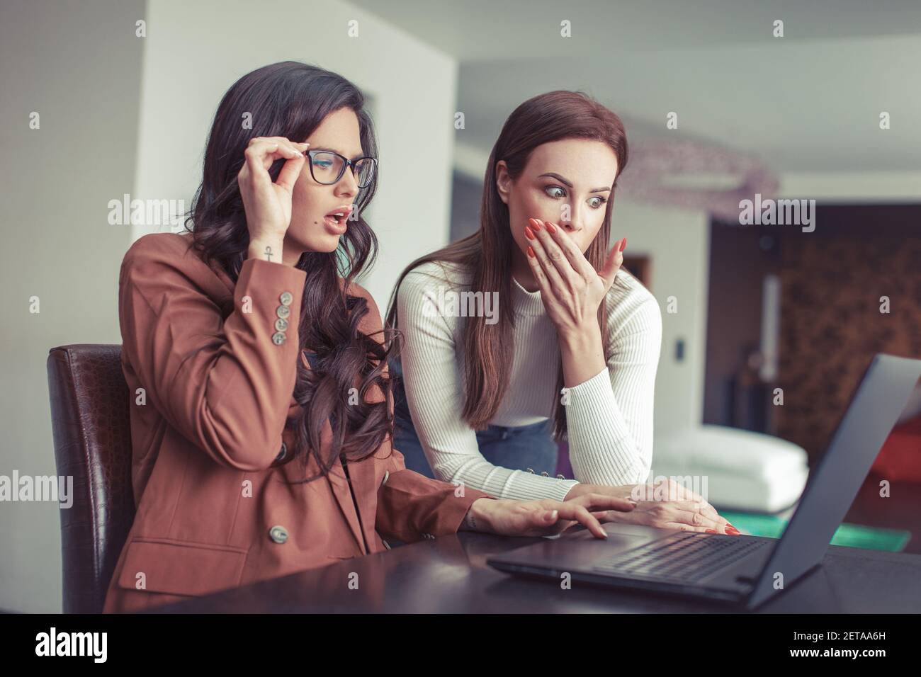 Young Caucasian surprised women watching something in the laptop Stock Photo