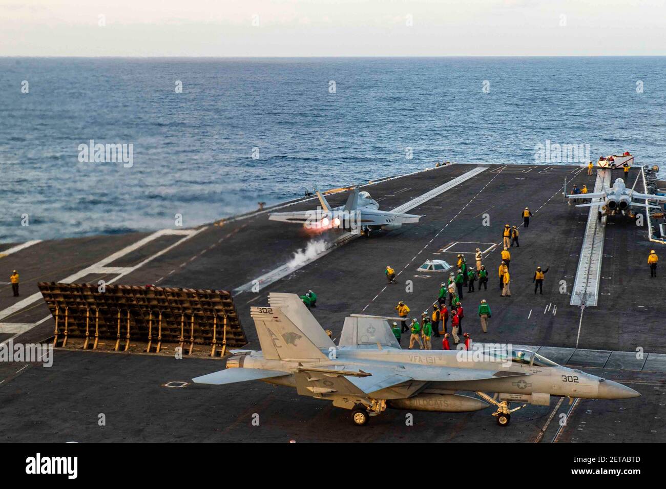 A U.S. Navy F/A-18F Super Hornet, from the Fighting Swordsmen of Strike Fighter Squadron 32, flies past the flight deck aboard the Nimitz-class aircraft carrier USS Dwight D. Eisenhower February 28, 2021 in the Atlantic Ocean. Stock Photo