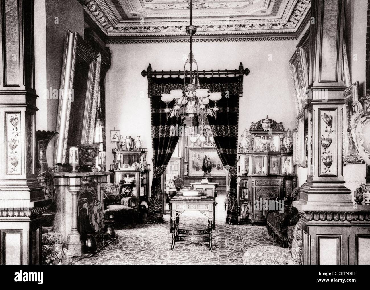 1880s PARLOR FURNITURE IN A MILLIONAIRE'S ORNATE HOME TURN OF THE 20TH CENTURY USA - o2371 SPL001 HARS LIVING ROOMS DRAPERY CARVED HOMES EXCESS ORNAMENTATION 19TH CENTURY CLUTTERED 1880s INTERIOR DESIGN PARLOR RESIDENCE STYLISH WOODWORK DETAILED MILLIONAIRE CEILING DECORATIVE DWELLING FIXTURES HOME DECOR LAVISH BLACK AND WHITE FURNISHINGS OLD FASHIONED Stock Photo