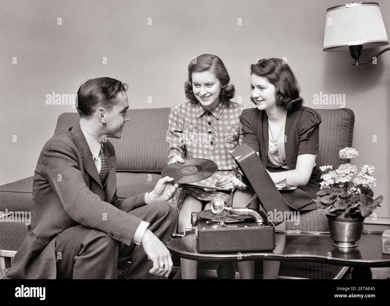 1930s 1940s GROUP OF TEENS TWO GIRLS ONE BOY SITTING TOGETHER PLAYING 78 RPM RECORDS ON PORTABLE PHONOGRAPH - s8945 HAR001 HARS 1 JUVENILE COMMUNICATION FRIEND YOUNG ADULT RECORDS VINYL JOY LIFESTYLE SOUND FEMALES HOME LIFE COPY SPACE FRIENDSHIP HALF-LENGTH LADIES PERSONS MALES TEENAGE GIRL TEENAGE BOY ENTERTAINMENT PORTABLE B&W PHONOGRAPH DATING HAPPINESS LEISURE RECORD PLAYER SOCIALIZING CONNECTION 78 RPM CONCEPTUAL FRIENDLY TEENAGED JUVENILES TOGETHERNESS YOUNG ADULT MAN YOUNG ADULT WOMAN BLACK AND WHITE CAUCASIAN ETHNICITY HAR001 OLD FASHIONED Stock Photo