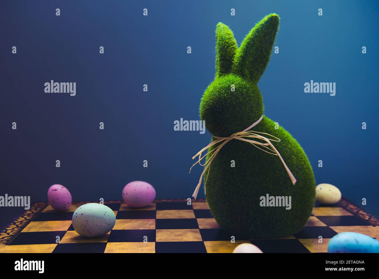 Creative and trendy Easter concept. Easter chess play with colored eggs and  Easter green bunny rabbit on the dark blue background. Selective focus  Stock Photo - Alamy