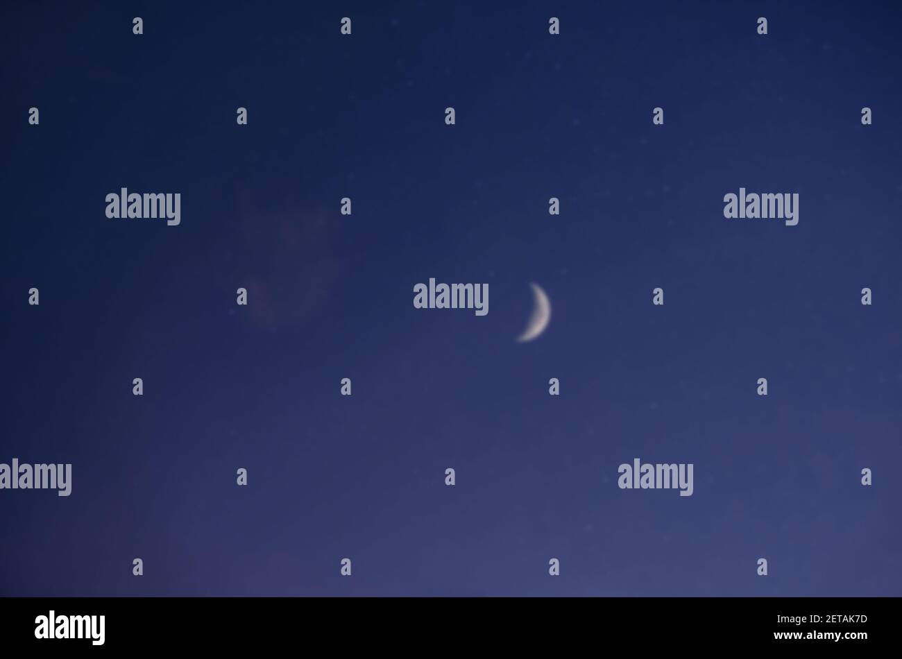 Defocused night landscape, dark blue starry sky, view of the bright moon (Crescent) in cloudless weather. Stock Photo