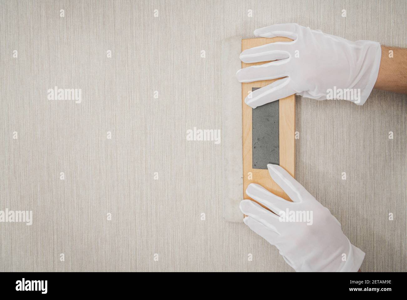 Worker with Clean White Gloves and Soft Wooden Vinyl Squeegee Smoothing  Tool Using For Modern Vinyl Wallpaper Application Stock Photo - Alamy