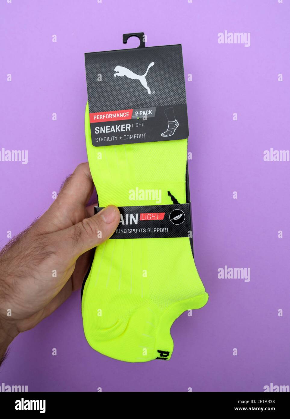 Paris, France - Oct 8, 2018: POV male hand holding new pair of Puma Sneaker  Light performance socks in vivid green color - isolated on violet  background Stock Photo - Alamy