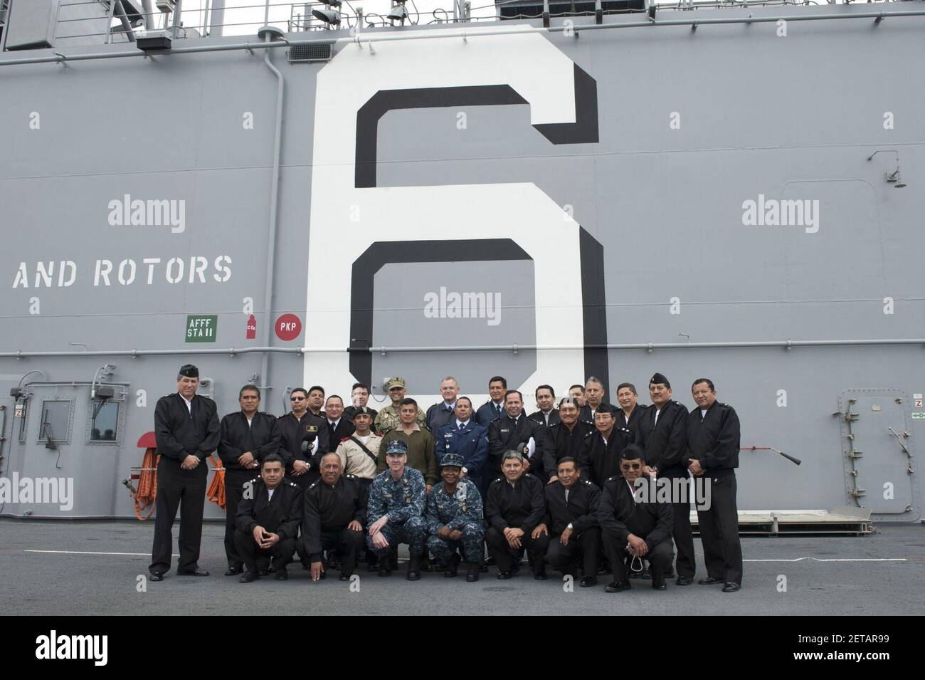 Peruvian service members pose for a photo with U.S. Navy Command Master Chief Chad Lunsford, front center left, the command master chief of the amphibious assault ship USS America (LHA 6), and Command Master 140902 Stock Photo