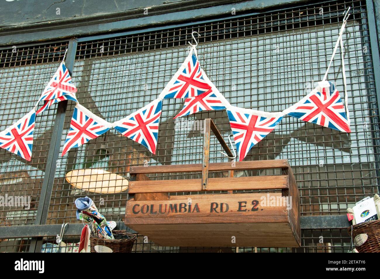 Union Jack or Flag bunting above trug box with Columbia Road, E2 printed on side outside shop in market Stock Photo