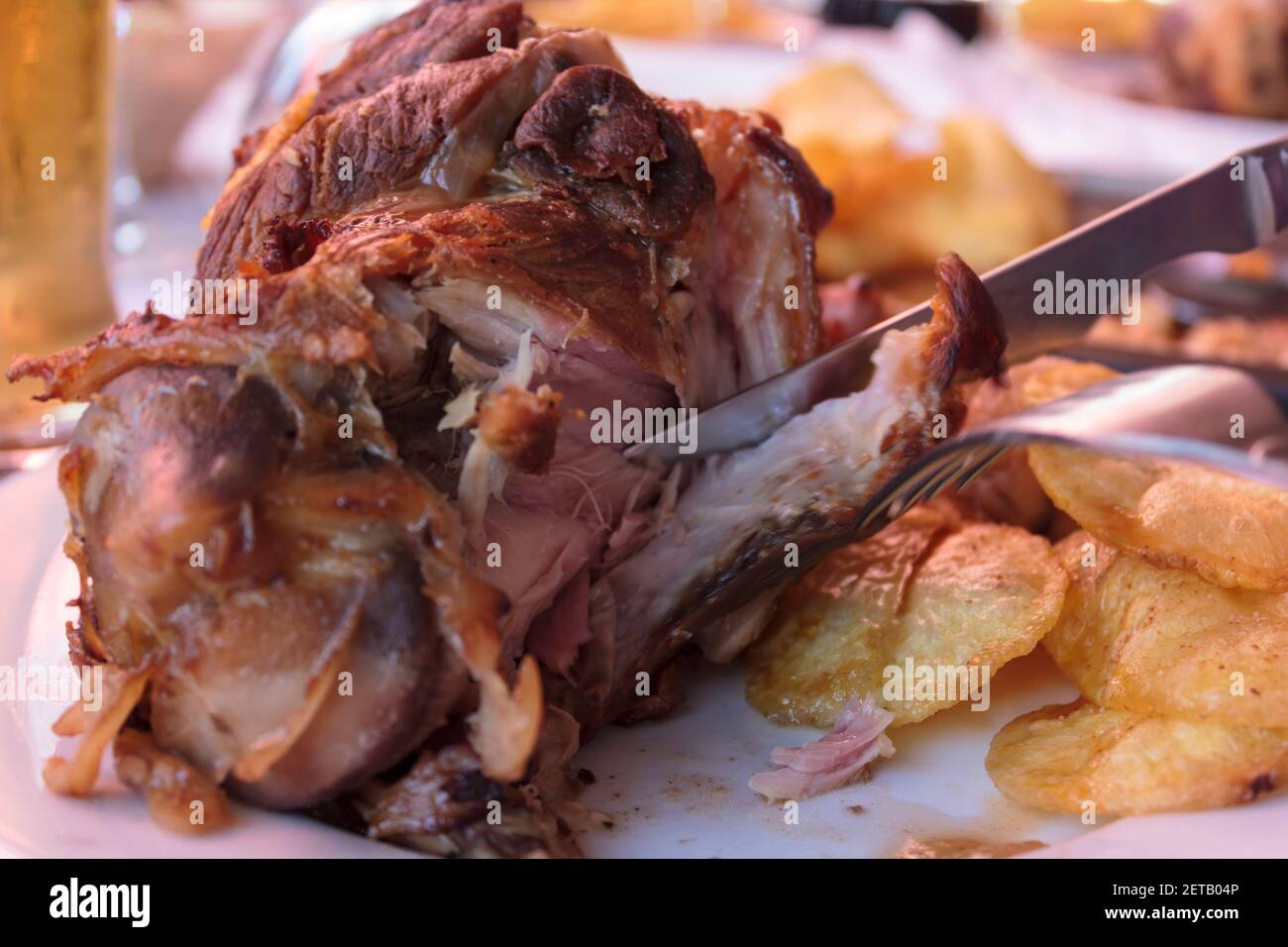 Eating roasted pork knuckle with french fries Stock Photo