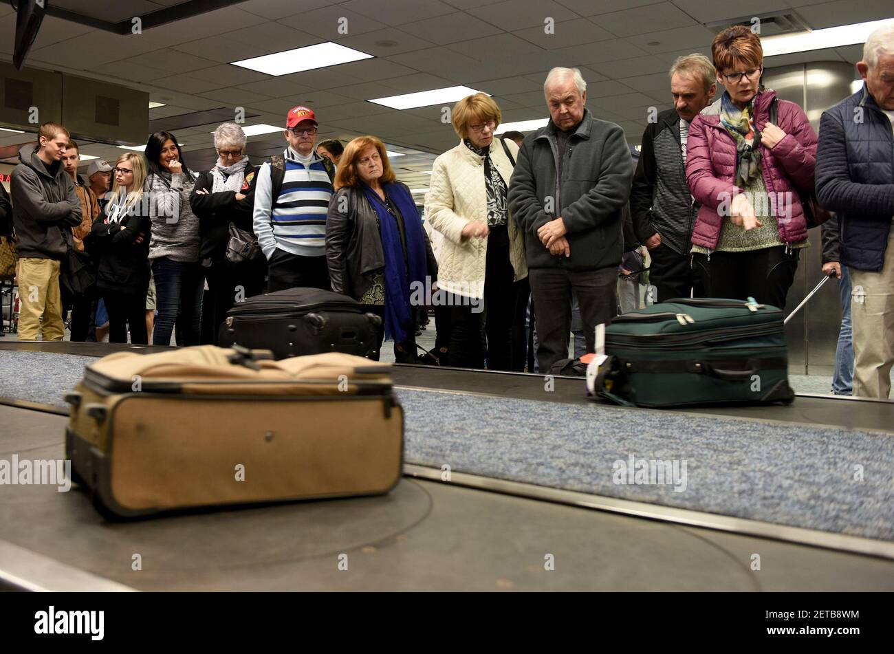 Air Canada passengers stand at the Terminal 2 baggage carousel looking