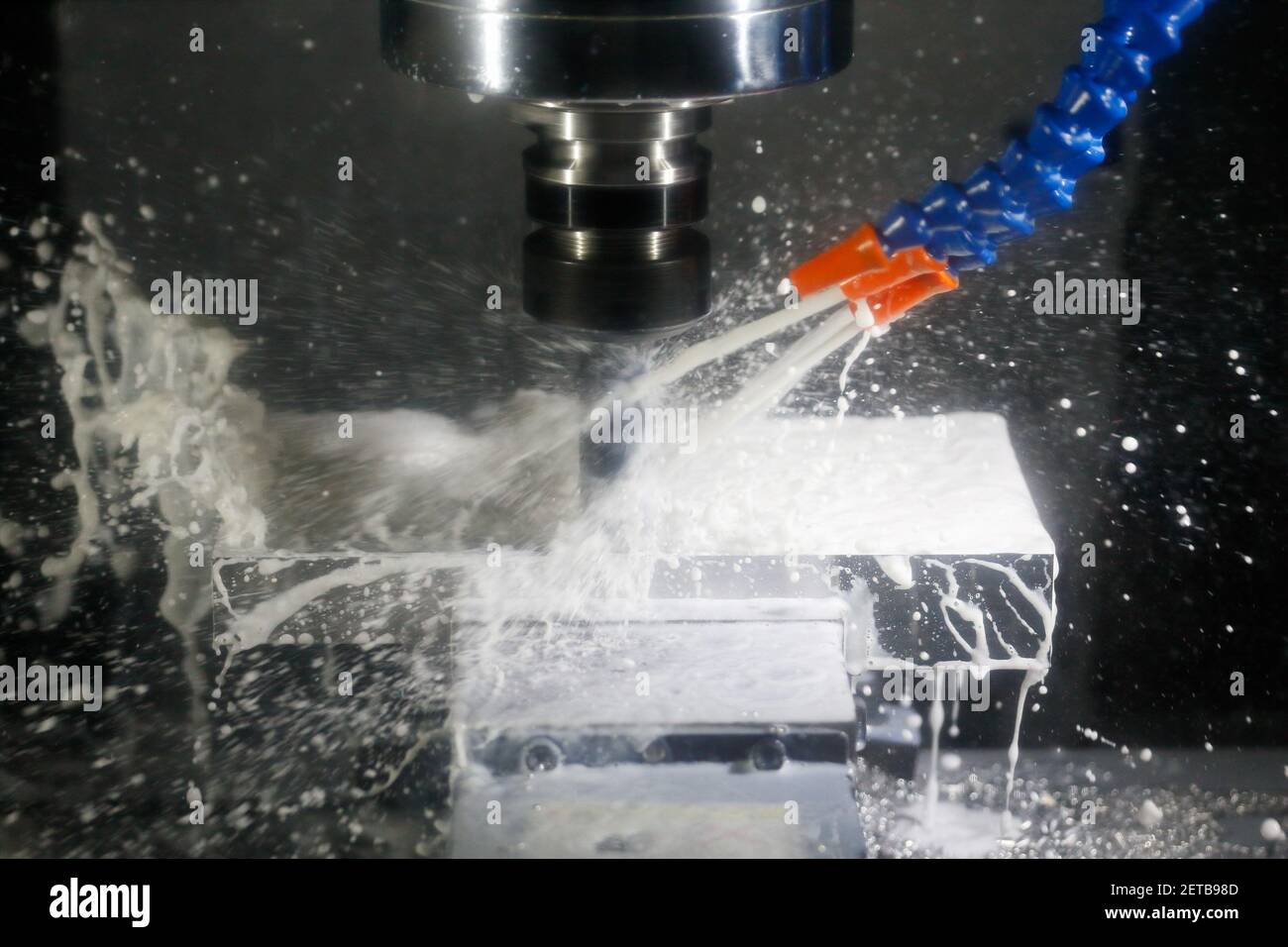 Milling process with coolant on a CNC machine. Milling process of aluminum using cutting fluid on a CNC milling machine. Selective focus. Stock Photo