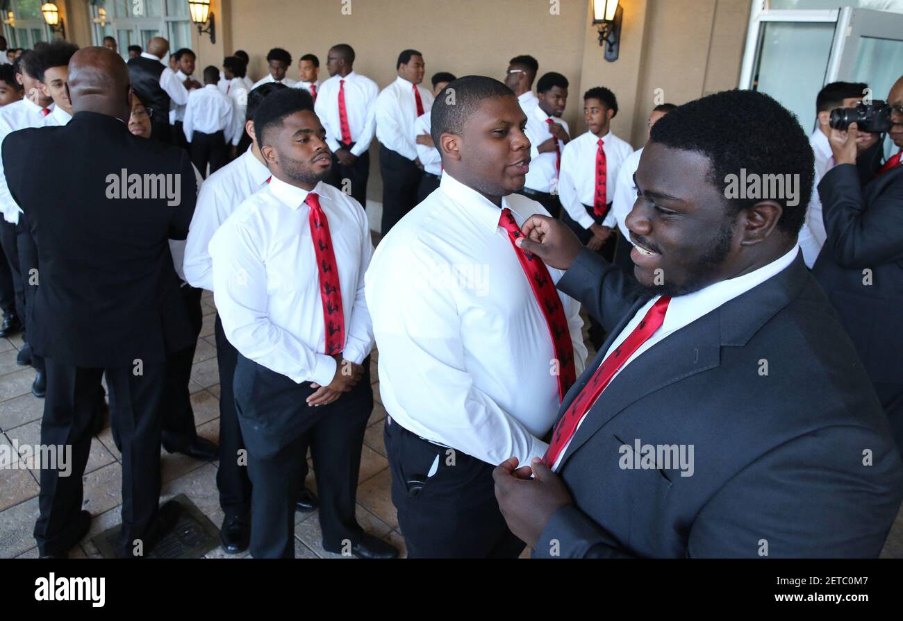 Jamaal West,18, of Miami Carol Senior High gets his tie straightened by ...
