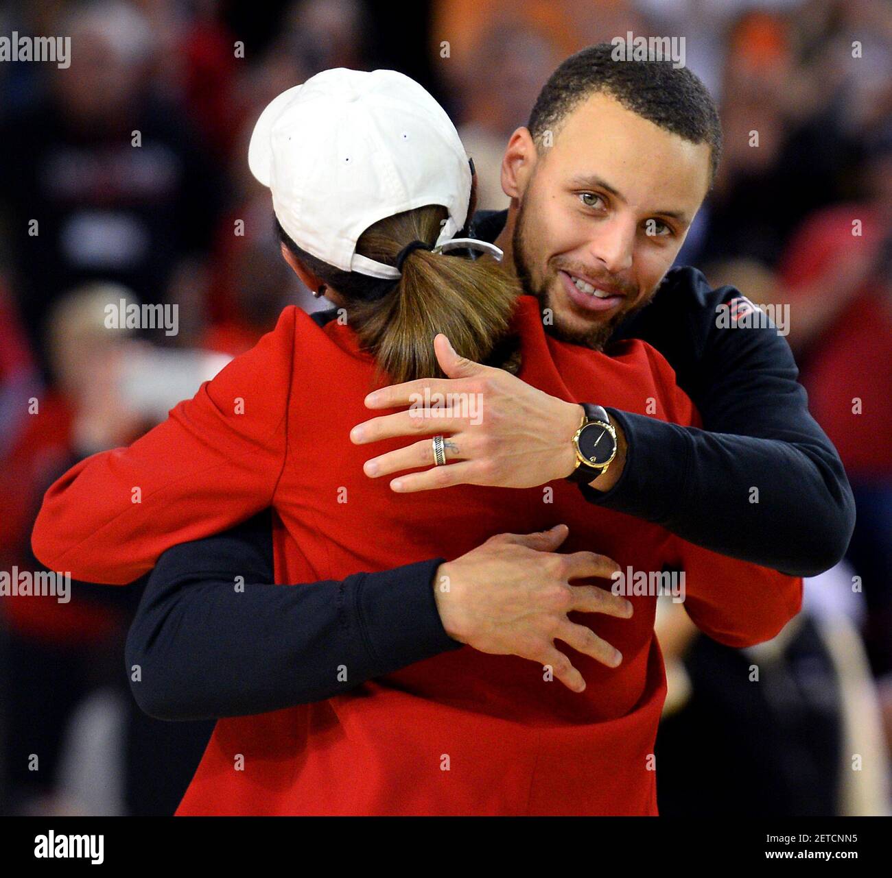 Davidson College president Carol Quillen, back to camera, hugs NBA star