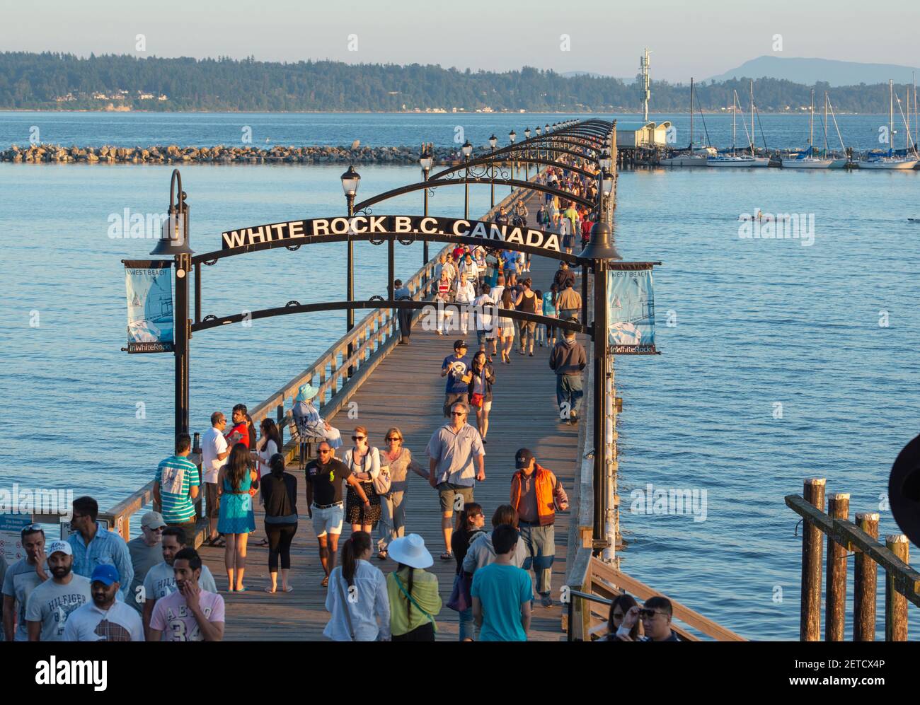 People walking on the pier in White Rock, British Columbia, Canada. This is the original pier before the storm destroyed it. Stock Photo