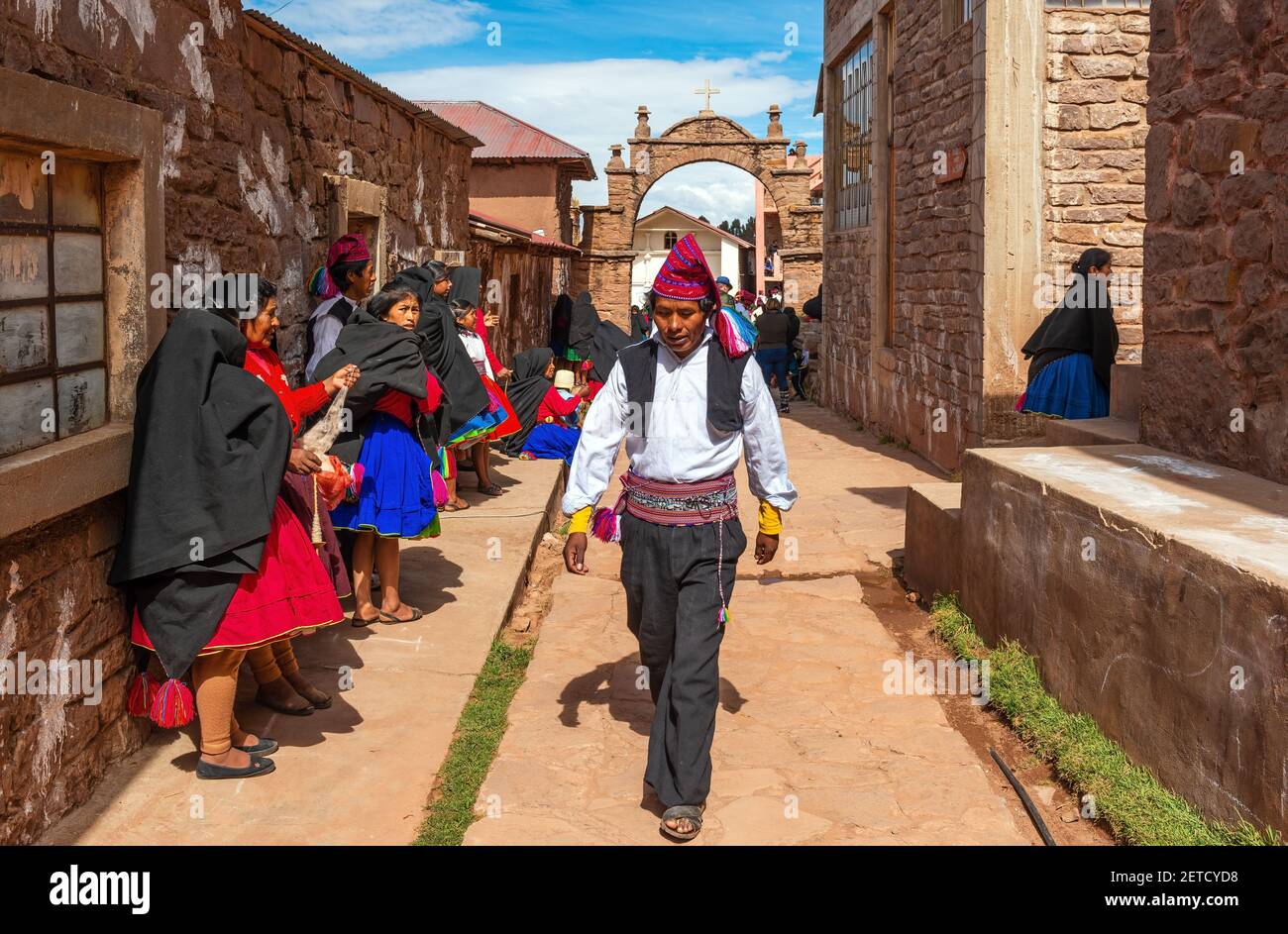 Indigenous Peruvian Quechua people in traditional clothing in a street of Taquile island, Titicaca Lake, Peru. Stock Photo