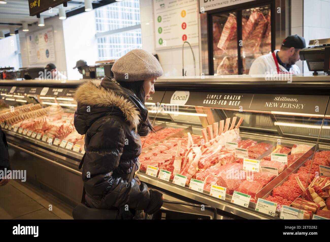 A shopper chooses cuts of meat in the new Whole Foods Market opposite  Bryant Park in New York on opening day Saturday, January 28, 2017. The  store in Midtown Manhattan is the