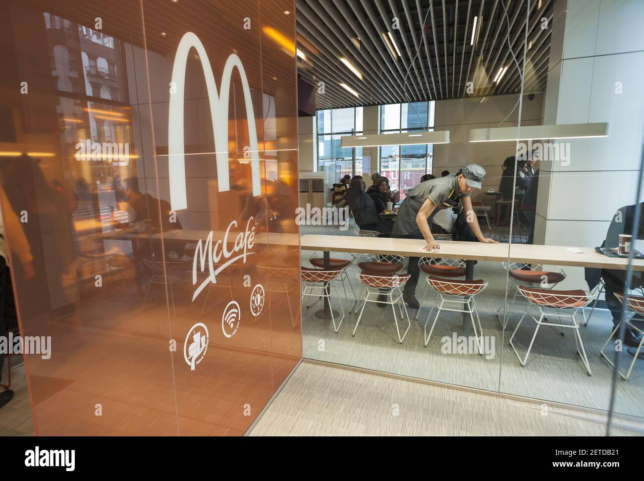 A worker cleans tables in a prototype McDonald's in New York, upscaling ...