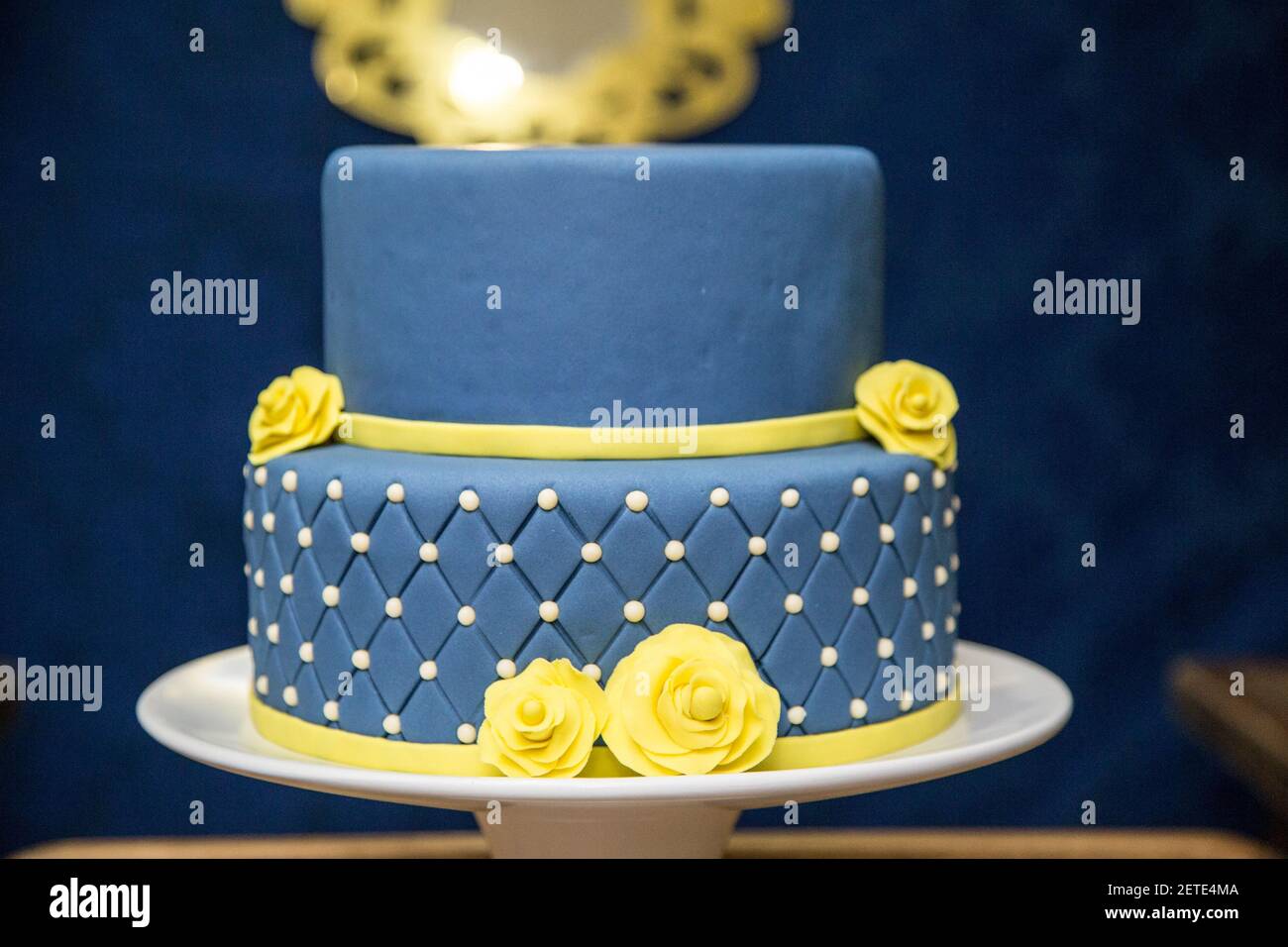 A selective focus shot of a blue fondant cake with yellow flowers design on  a tray Stock Photo - Alamy