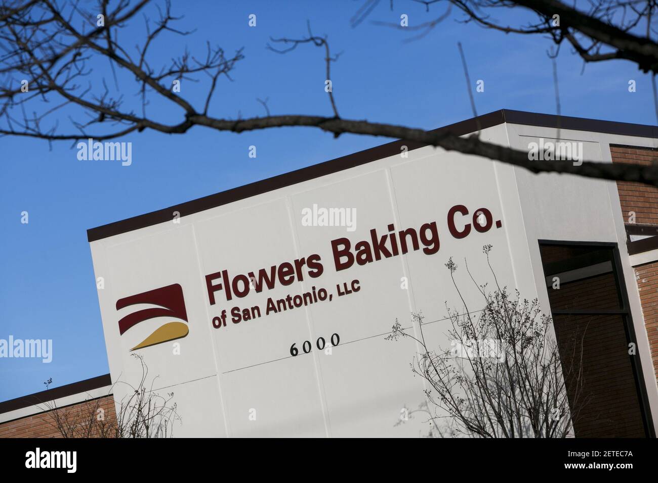 A logo sign outside of a facility occupied by the Flowers Baking