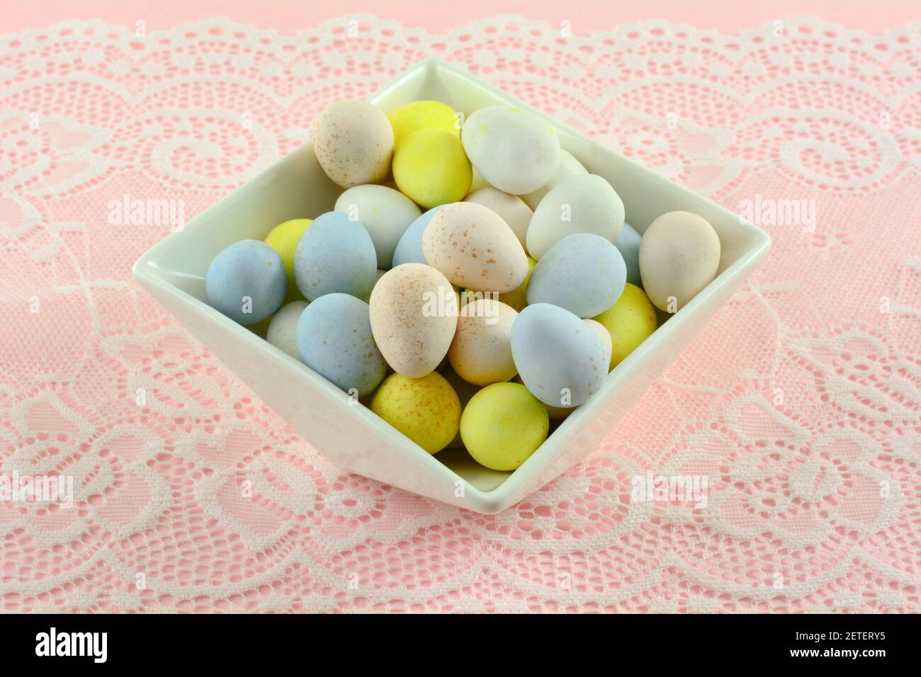 Pastel colored candy Easter eggs in white dessert bowl Stock Photo