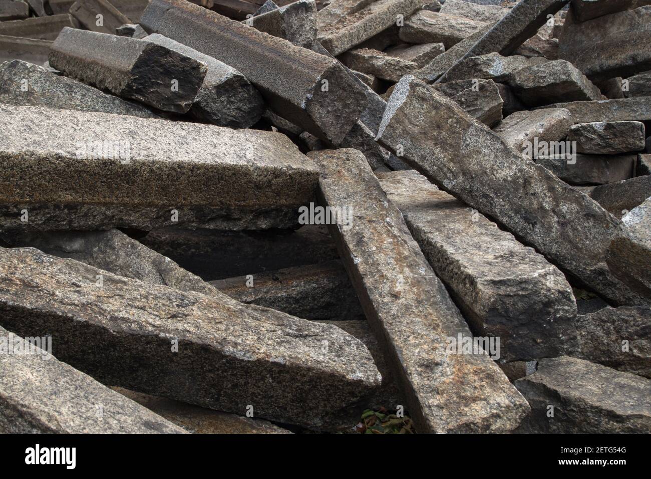 Piled up, lying in disarray old rectangular cement grey road curbs piled up in connection with road maintenance, abstract rough background Stock Photo