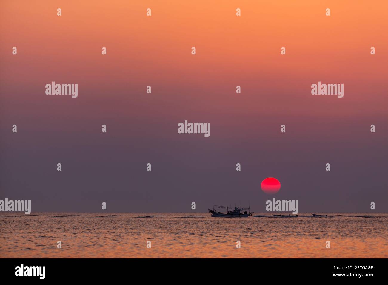 A boat traverses the ocean near Seongsan Ilchulbong on Jeju island in South Korea. Stock Photo