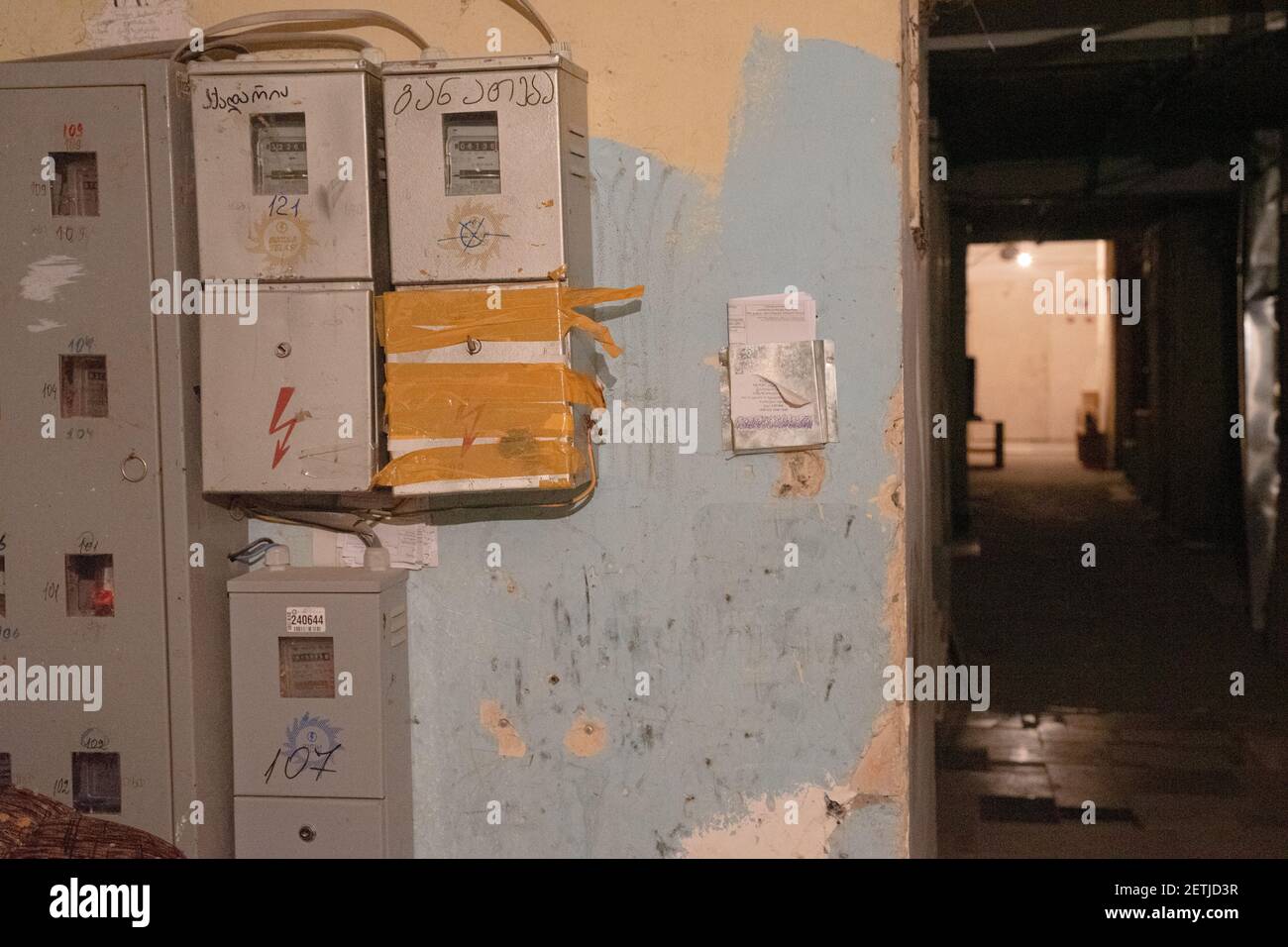 Old electricity meters on the battered wall in the foyer of the old