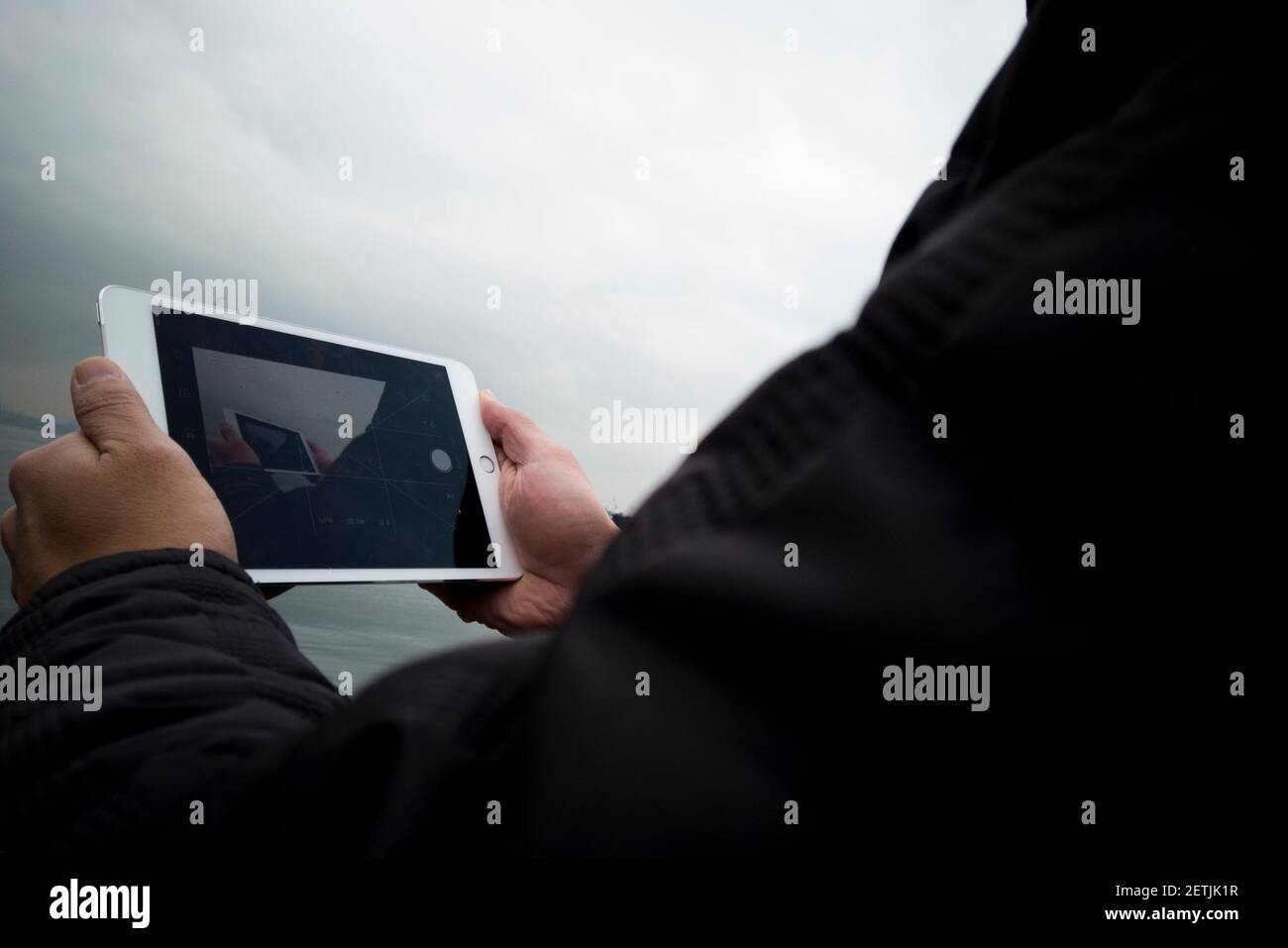 man holding tablet in foggy day outside shot Stock Photo