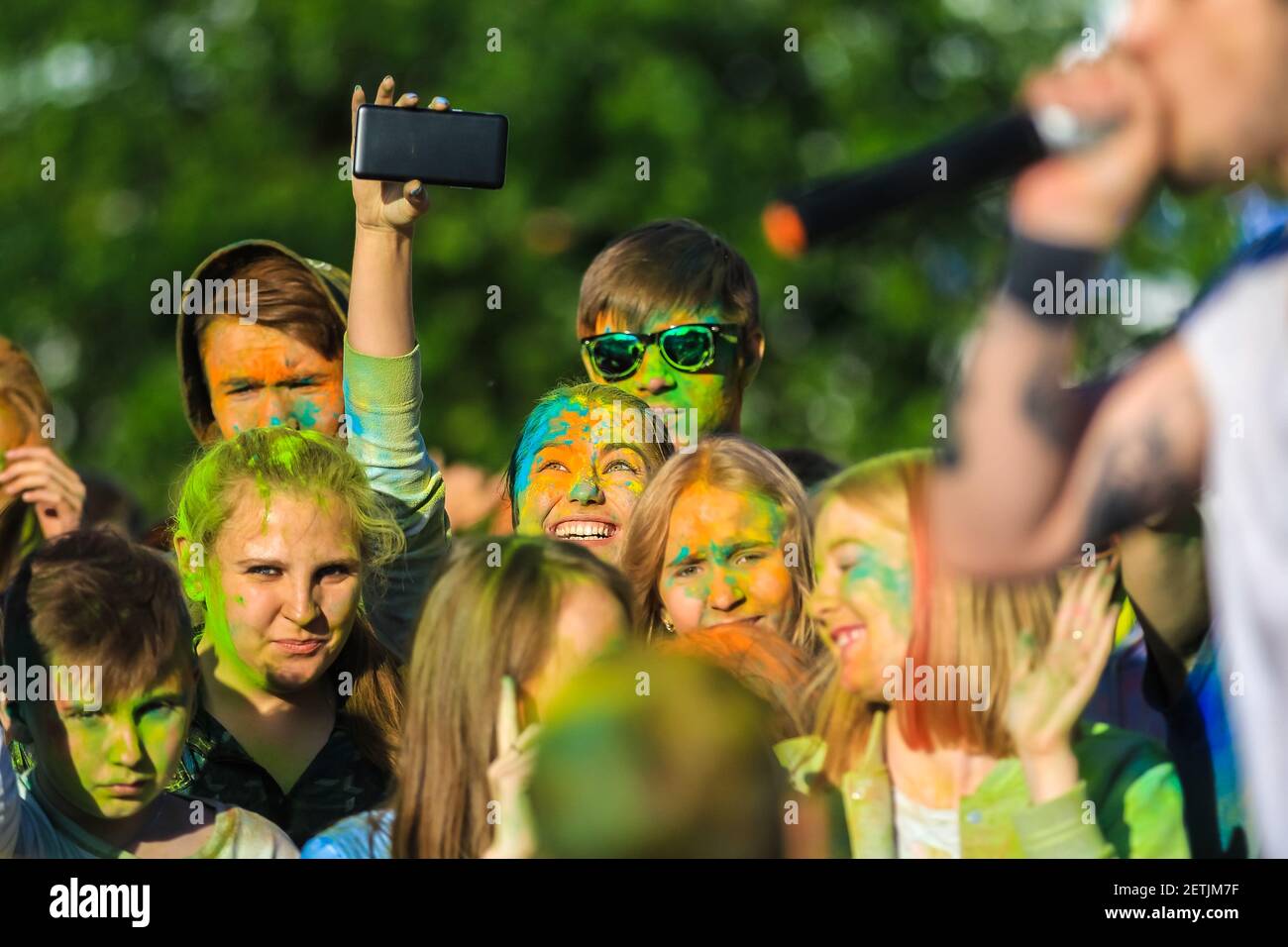 Russia, Moscow - June 25, 2017. Portrait of a girl with bright flowers on her face. Laughs with happiness. Holi is a traditional holiday in India Stock Photo