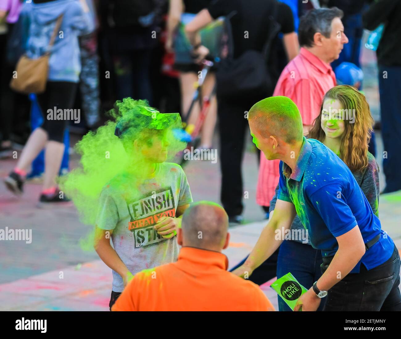 Russia, Moscow - June 25, 2017. Cheerful, young people throw themselves bright colors. Happy faces of adults and children are stained with paint. Holi Stock Photo