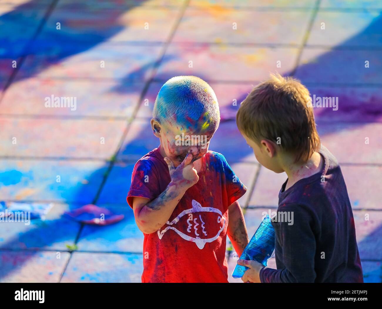 Russia, Moscow - June 25, 2017. Little boy with bright colors on his face. Laughs with happiness. Holi is a traditional holiday in India Stock Photo