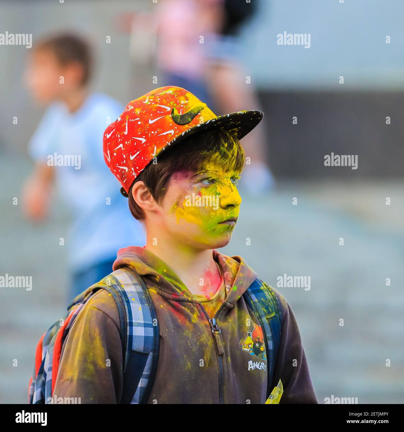 Russia, Moscow - June 25, 2017. Portrait of a young man with bright colors on his face. Laughs with happiness. Holi is a traditional holiday in India Stock Photo