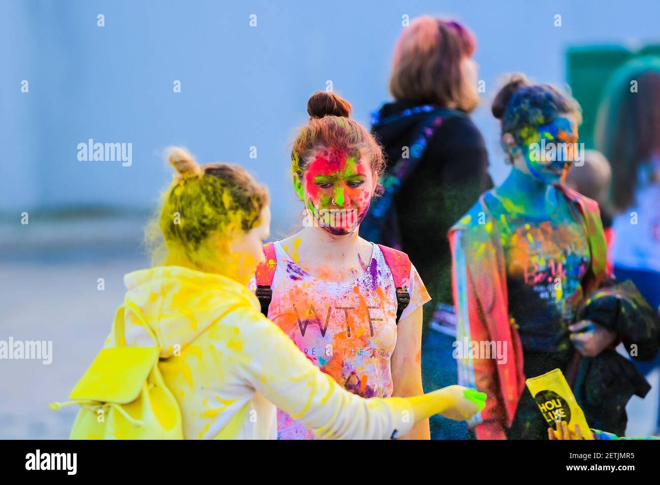 Russia, Moscow - June 25, 2017. Portrait of a girl with bright flowers on her face. Laughs with happiness. Holi is a traditional holiday in India Stock Photo