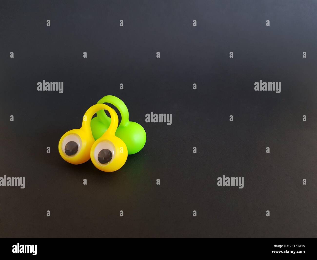 Speech therapy toys eyes on fingers on a black isolated background Stock Photo