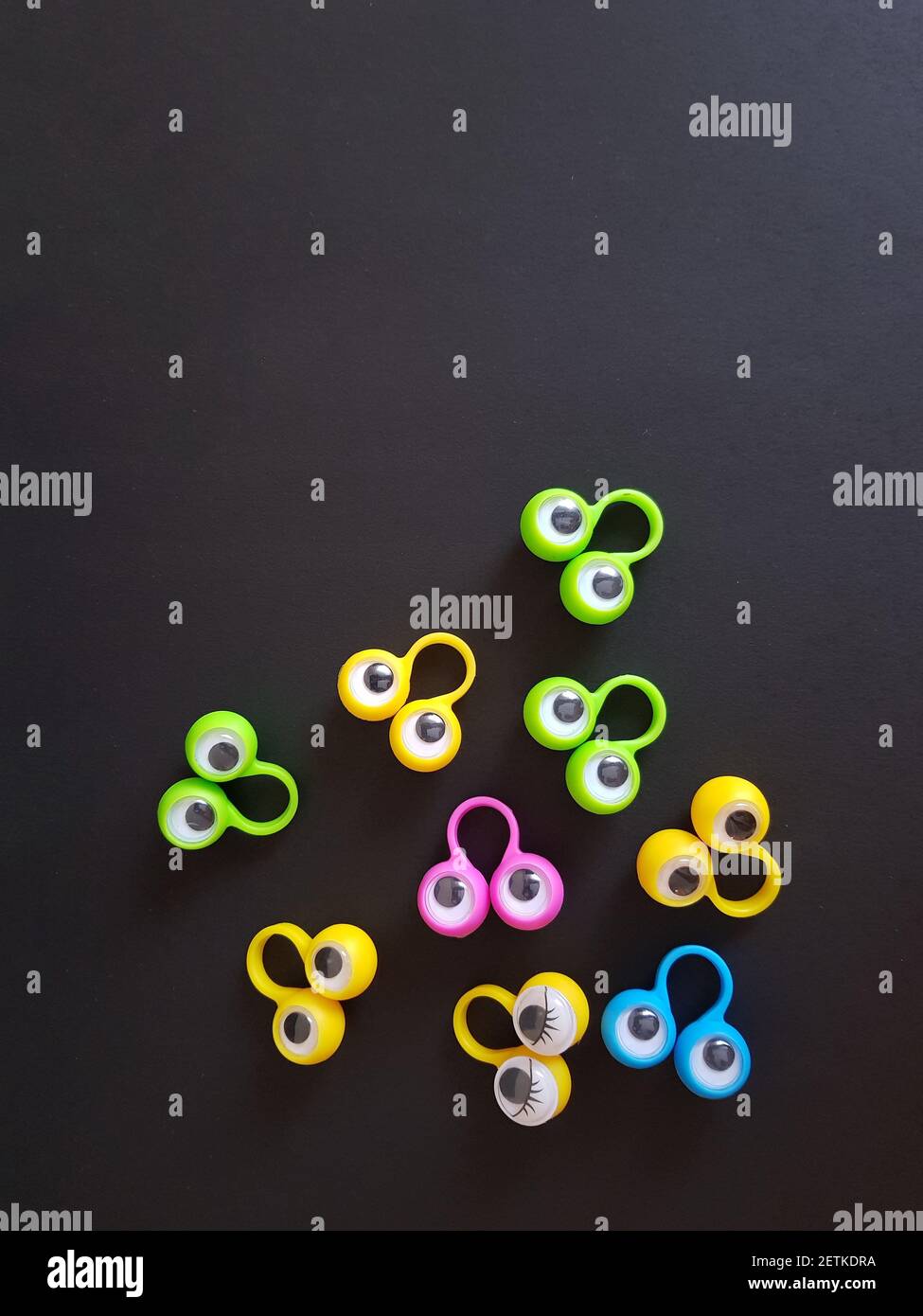 Speech therapy toys eyes on fingers on a black isolated background Stock Photo