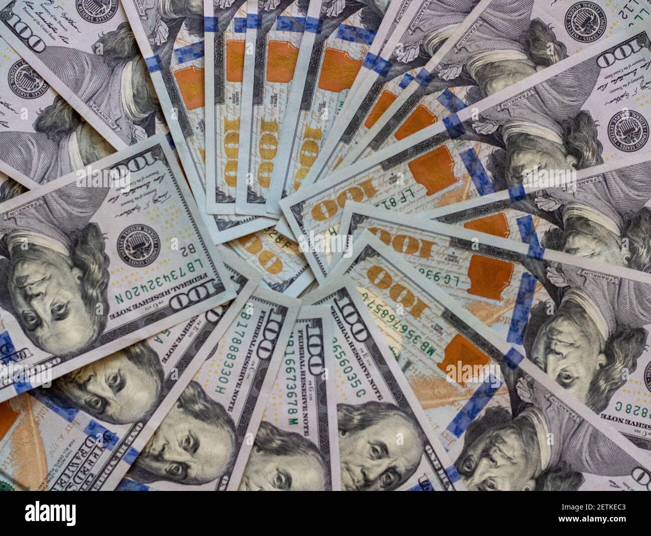 Background of hundred-dollar bills, the texture of dollars. A stack of hundred dollar bills spread out in a circle Stock Photo